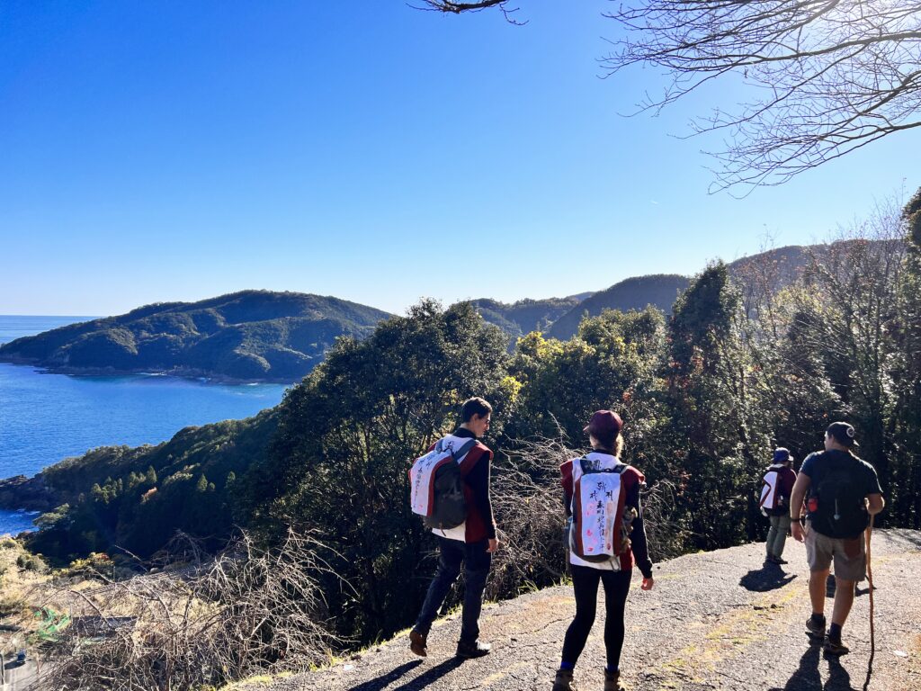 Hikers on a ridge path looking out over the Pacific coast on the Kumano Kodo Iseji route