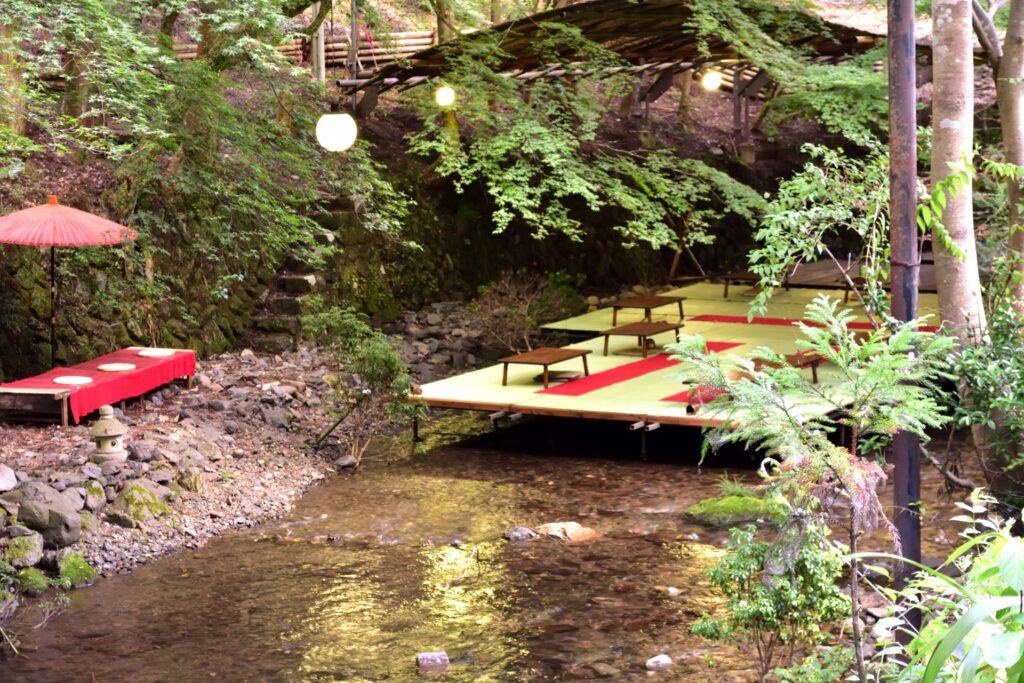 A kawadoko dining platform set out over the Kibune river among fresh greenery