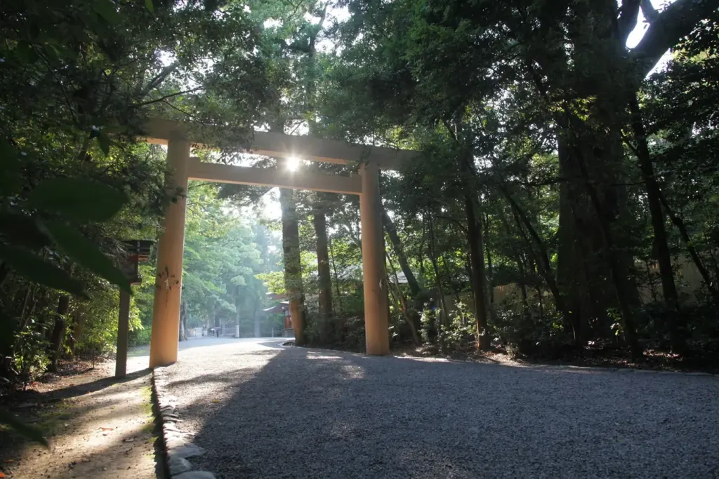 A wooden torii gate and gravel approach path leading through the forest at Ise Jingu