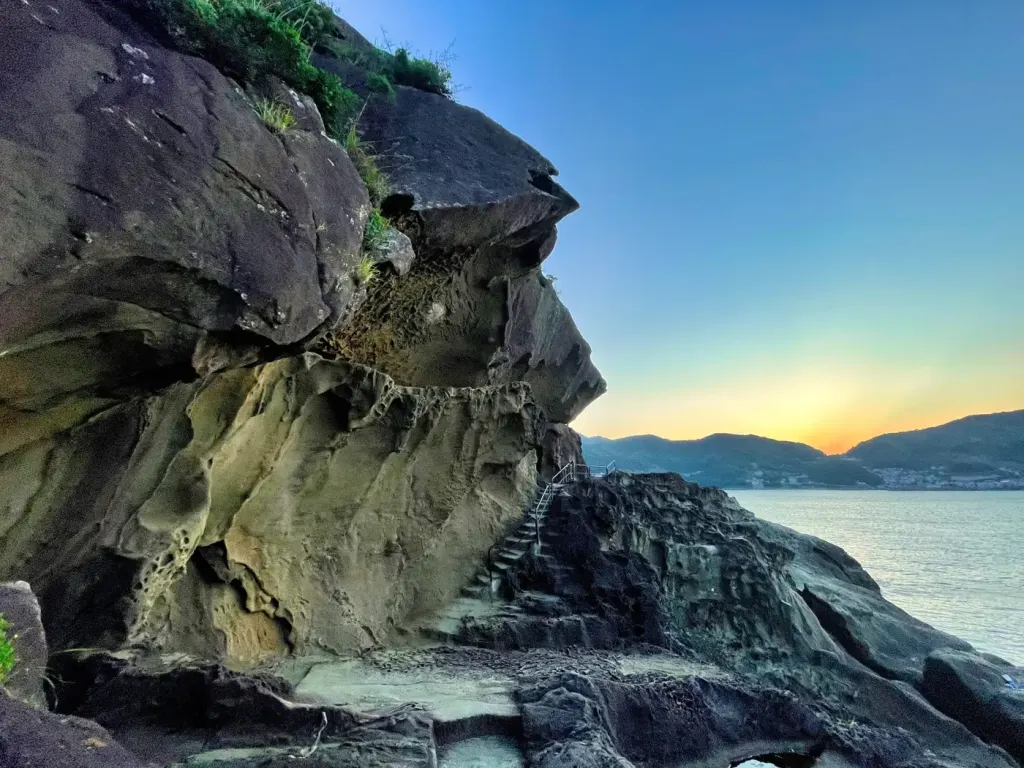 Wave-carved rock formations along the Onigajo coast at sunset