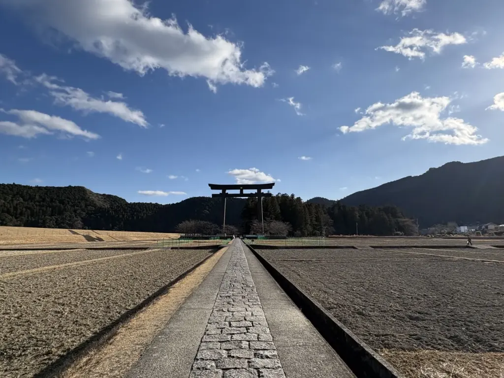 The giant Otorii gate at Oyunohara rising above open fields under a wide sky