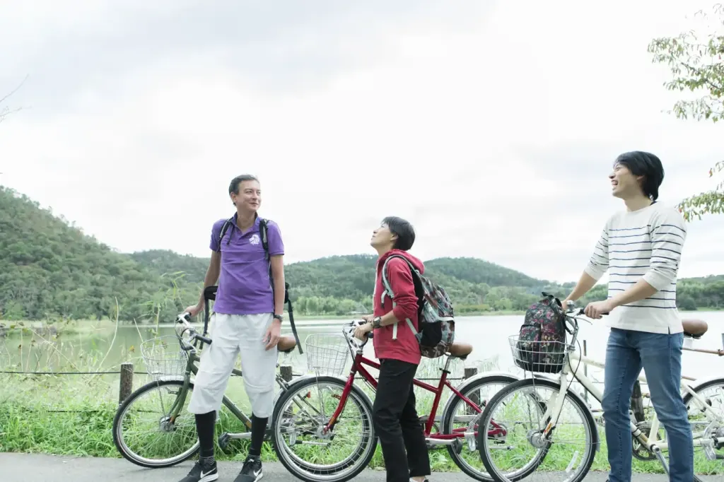 Three cyclists pausing with their bicycles in the countryside on the edge of Kyoto