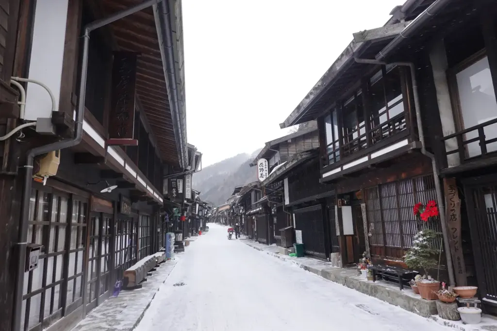 The quiet main street of Narai-juku, lined with two-storey wooden inns on a misty morning